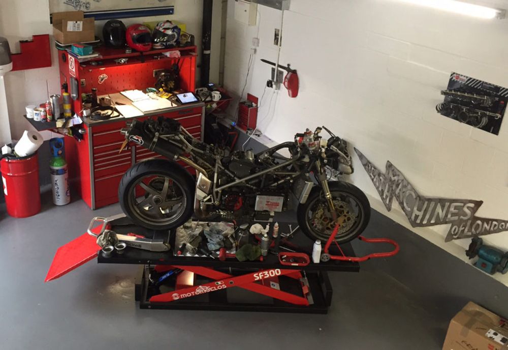 Stripped-down Ducati on a bench lift in the workshop