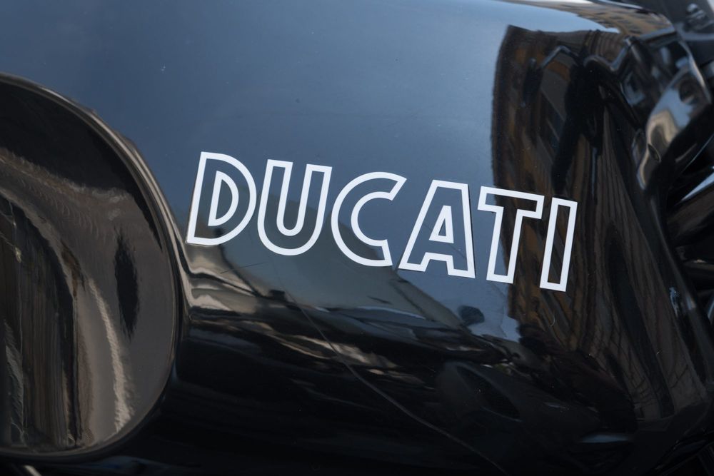 White Ducati lettering on a glossy black fuel tank