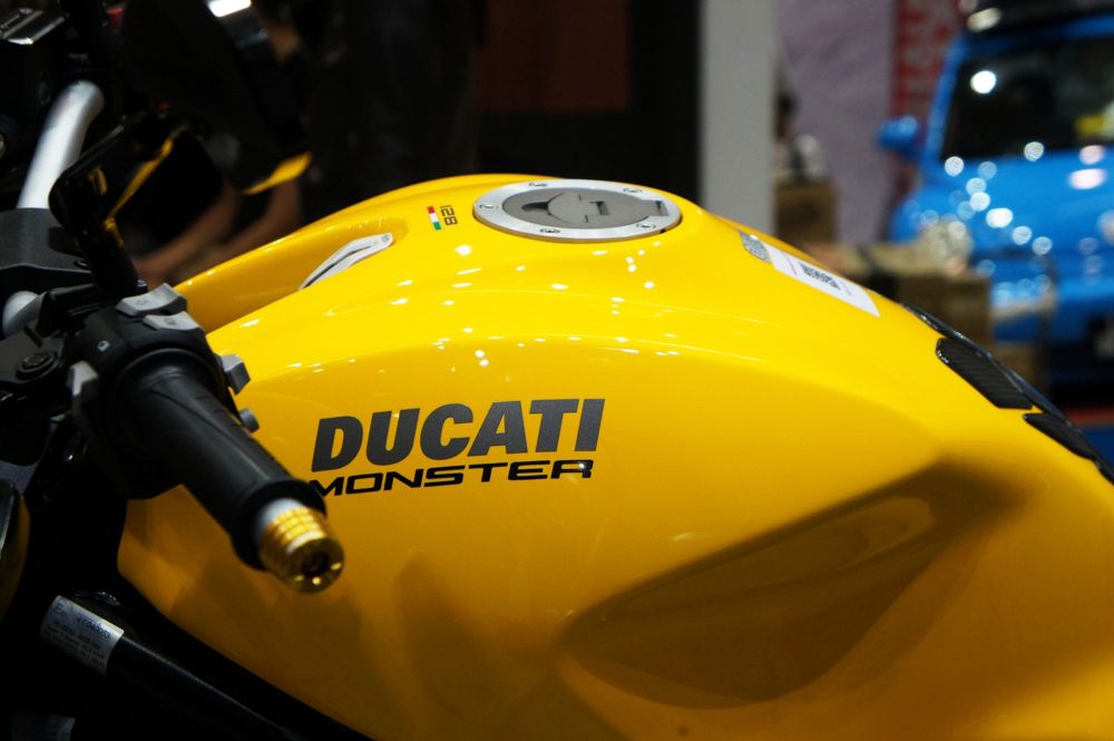 Yellow fuel tank of a Ducati Monster, with the Monster badge