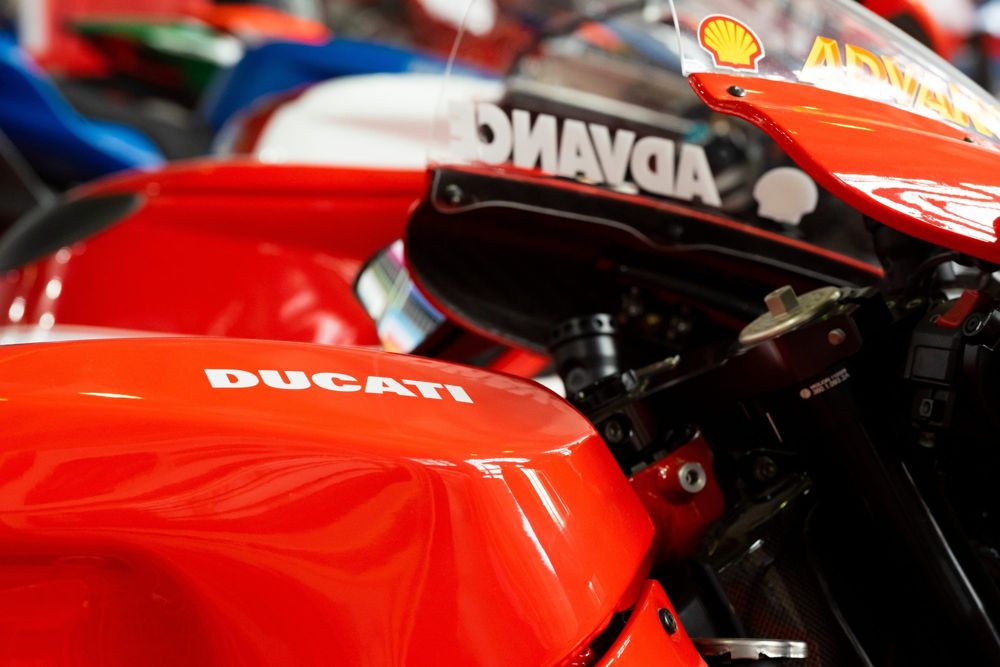 Red Ducati superbike tank, with a race replica behind it