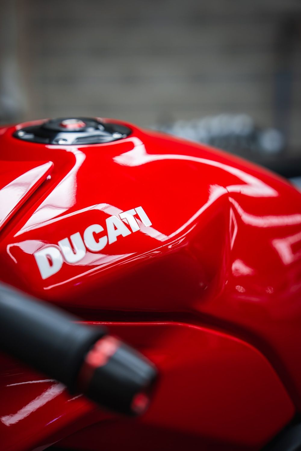 Red Ducati fuel tank and bar end in close-up