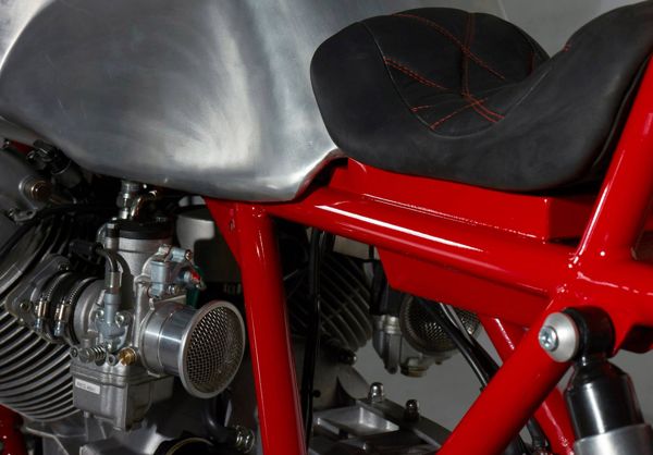 Carburettor, red frame and black seat of the custom Moto Guzzi