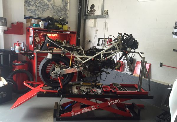 Motorcycle frame stripped back on a bench lift