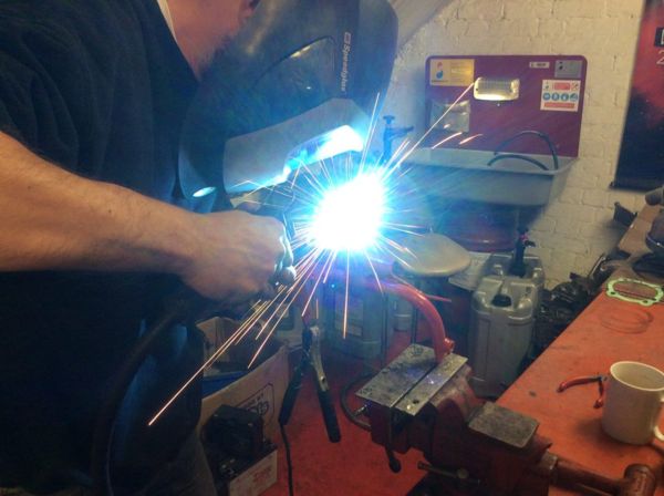Welding a motorcycle part in the RPM workshop