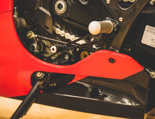 Desmosedici RR footpeg, gear lever and carbon belly pan in close-up