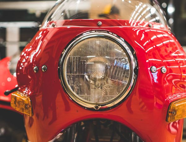 Round headlight and red fairing of a classic Ducati