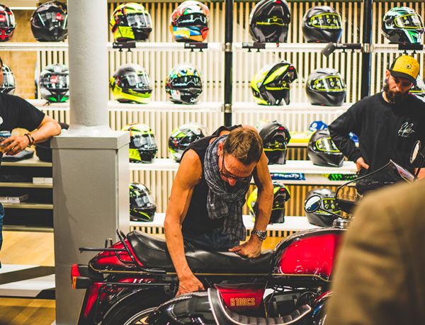 Guest looking over a motorcycle among the helmet displays