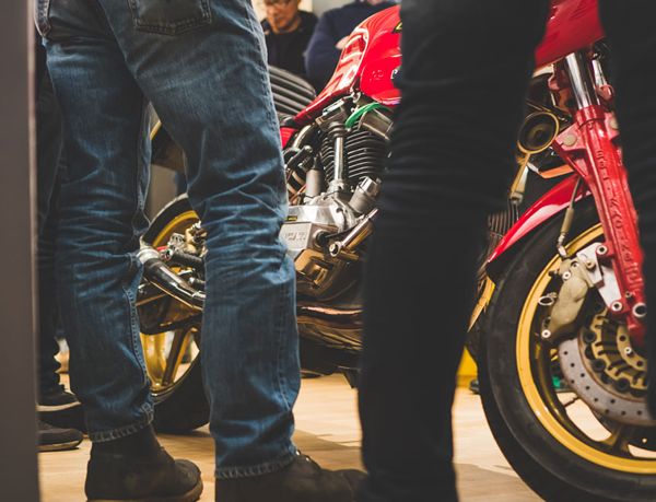 Guests standing around a red classic Ducati at the event
