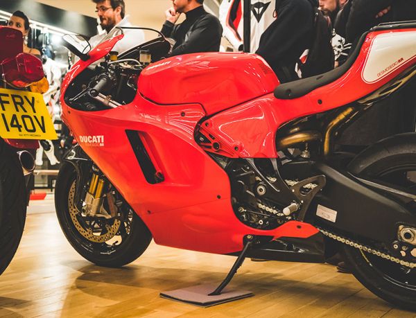 Red and white Ducati Desmosedici RR on its stand at an indoor event