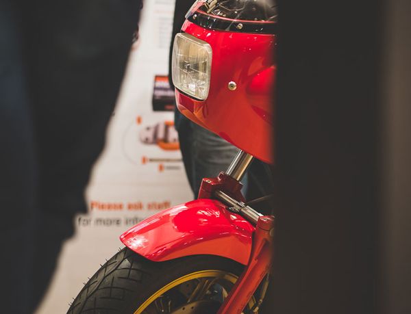 Red fairing and front wheel of a classic Ducati on display