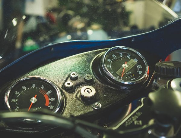Speedometer and rev counter of a classic Ducati with blue bodywork