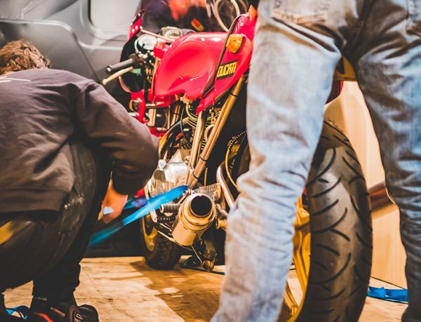 RPM mechanics working on a red Ducati at the event