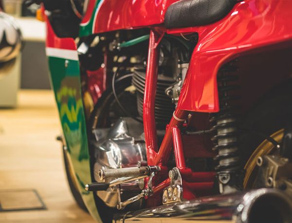 Red frame, rear shock and footpeg of a classic Ducati