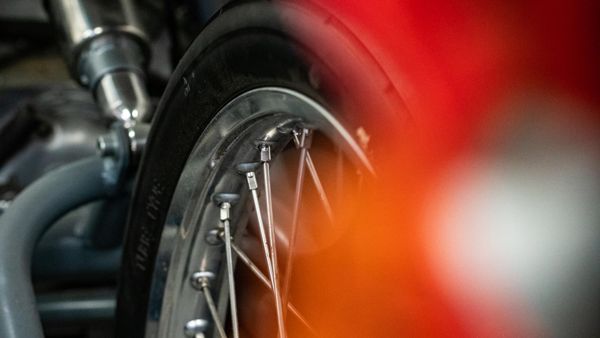 Spoked wheel and red bodywork in the workshop