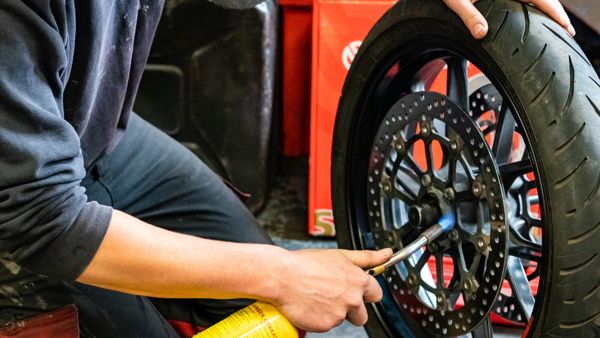 Mechanic tightening a brake disc bolt on a Ducati front wheel