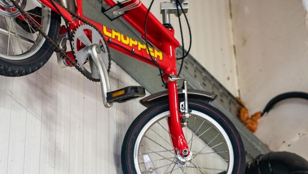 Red Chopper bicycle hanging on the workshop wall