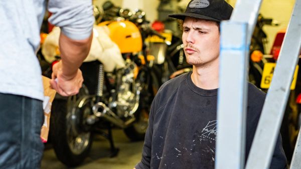 RPM mechanic talking to a customer beside a yellow Ducati