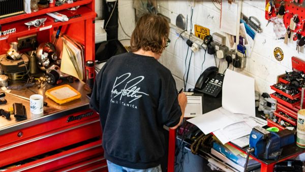 Mechanic at the workbench writing up a job among the tool chests