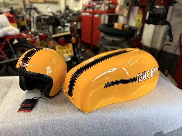 Yellow painted helmet beside a matching yellow Ducati fuel tank