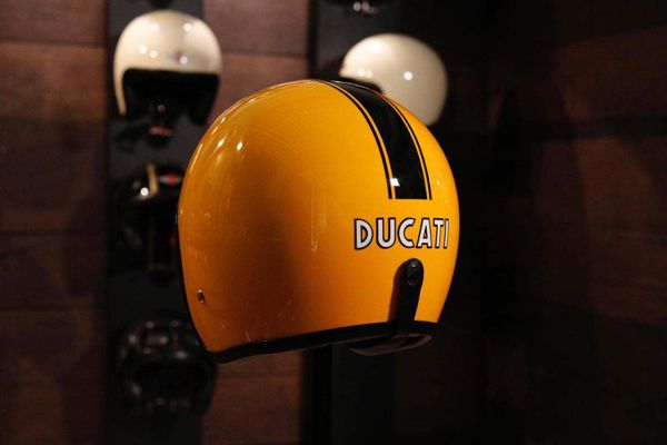 Yellow open-face helmet hand-painted with a black stripe and Ducati lettering