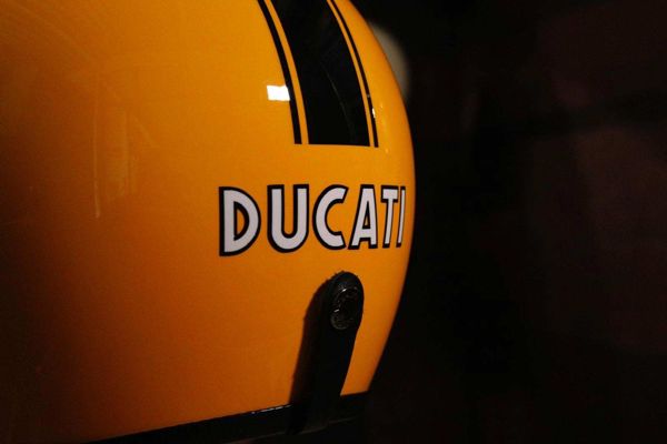 Ducati lettering hand-painted on a yellow helmet with a black stripe