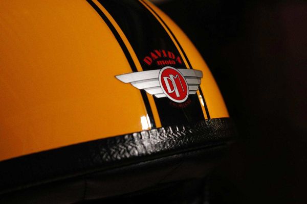 Winged DAViDA badge between black stripes on a yellow painted helmet