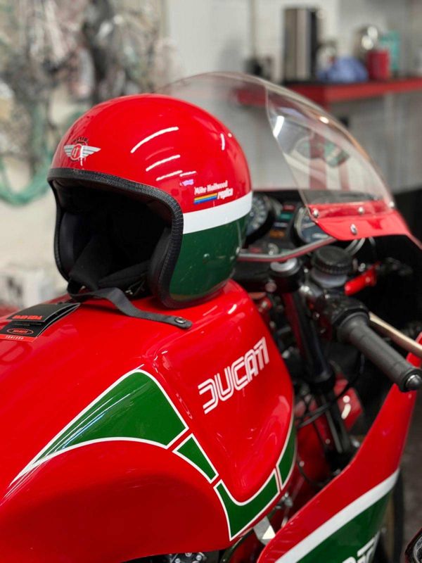 Open-face helmet painted in red, white and green to match a Ducati fuel tank