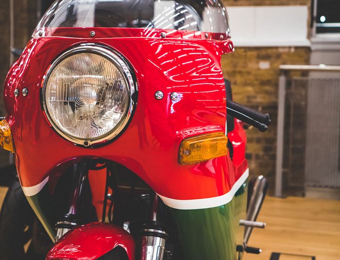 Red, green and white classic Ducati with a round headlight