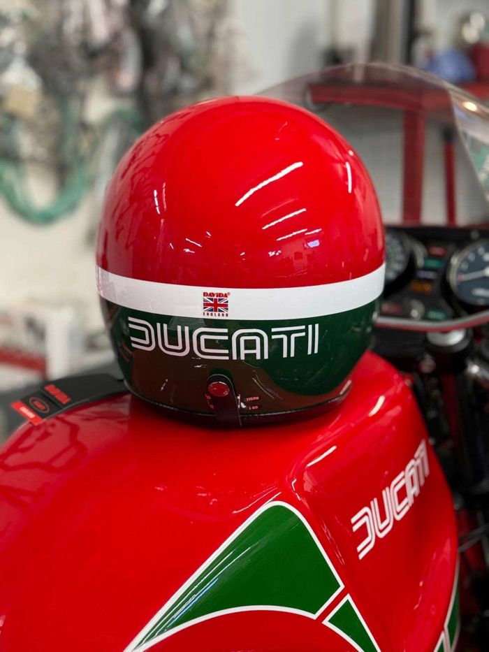 Red, white and green hand-painted helmet with Ducati lettering, on a matching Ducati