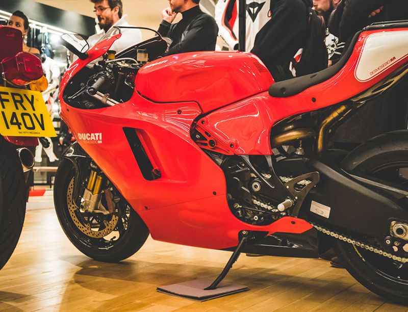 Red and white Ducati Desmosedici RR on its stand at an indoor event